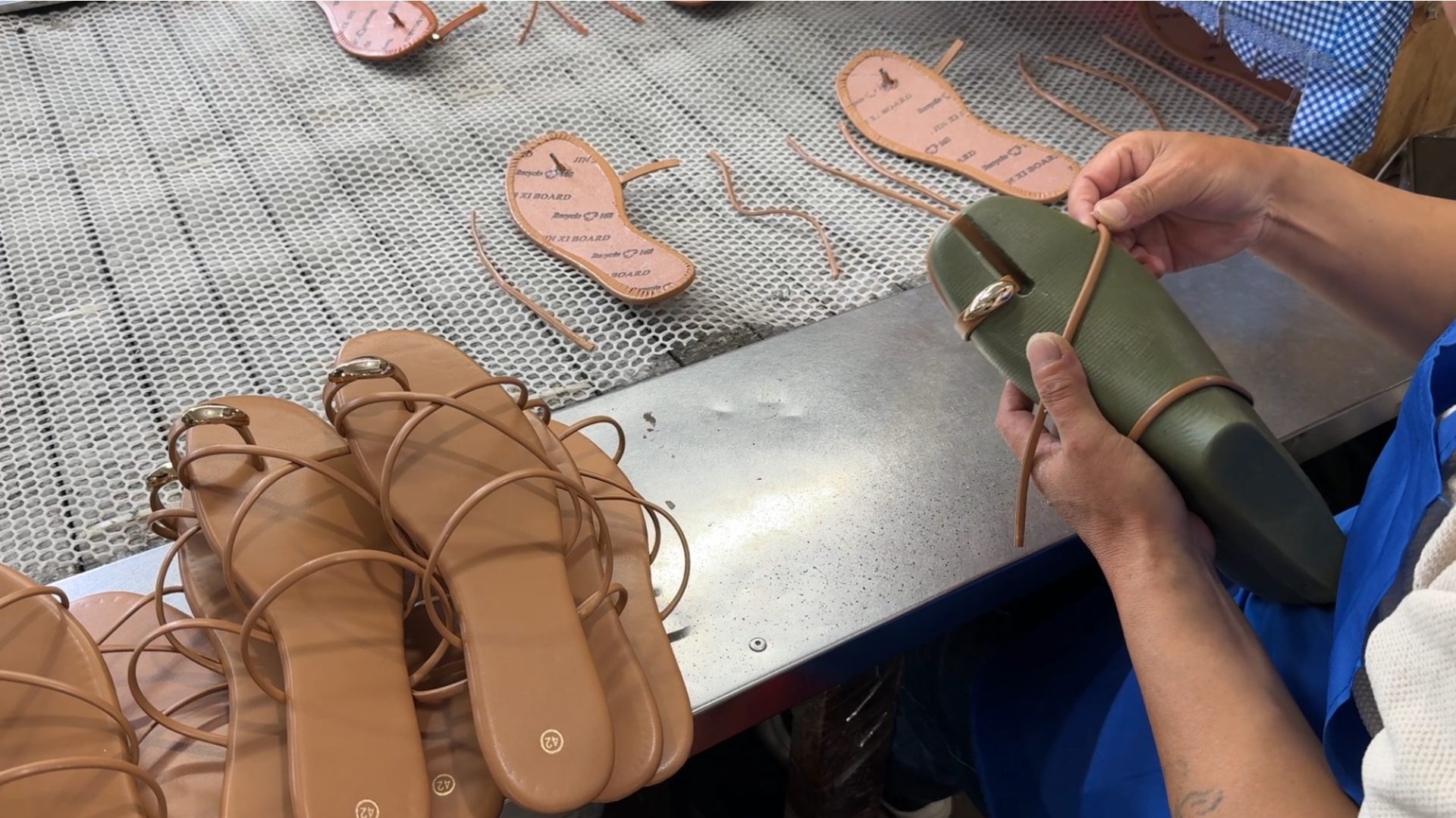 Skilled craftsman hand-binding sandals at our factory